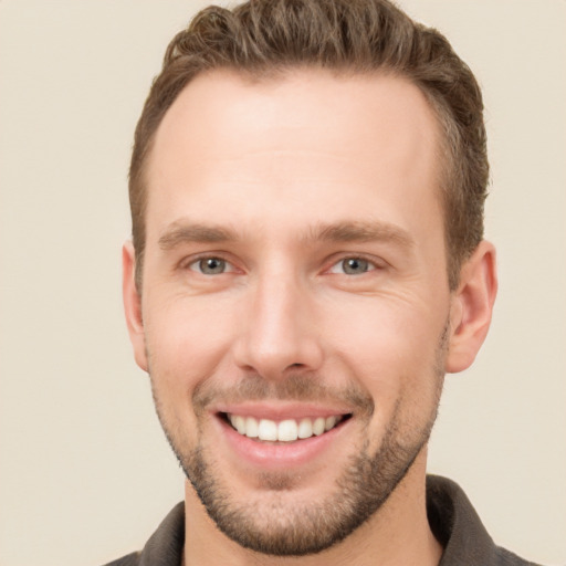 Joyful white young-adult male with short  brown hair and grey eyes