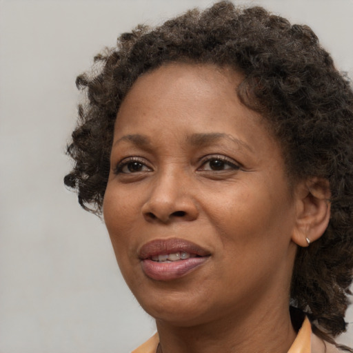 Joyful black adult female with medium  brown hair and brown eyes