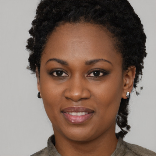 Joyful black young-adult female with short  black hair and brown eyes