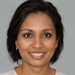 Joyful black young-adult female with medium  brown hair and brown eyes