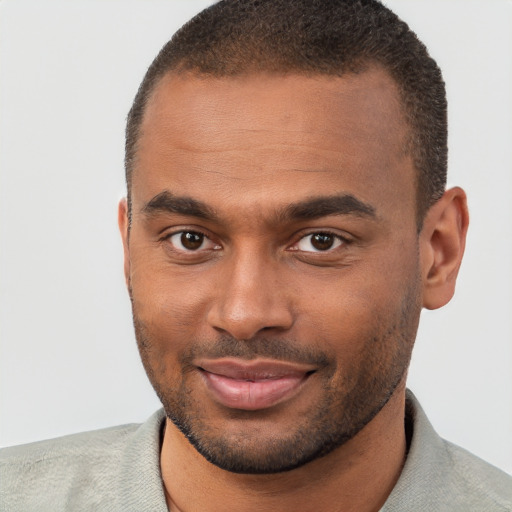 Joyful black young-adult male with short  brown hair and brown eyes