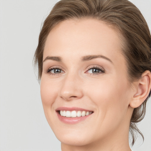 Joyful white young-adult female with medium  brown hair and blue eyes