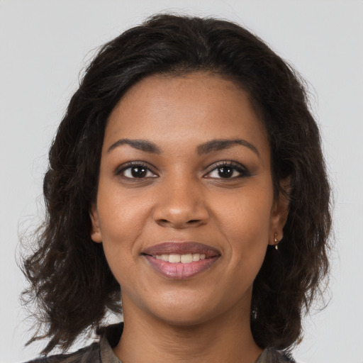 Joyful black young-adult female with medium  brown hair and brown eyes
