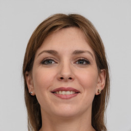 Joyful white young-adult female with long  brown hair and grey eyes