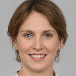 Joyful white young-adult female with medium  brown hair and green eyes