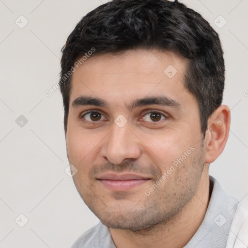 Joyful white young-adult male with short  black hair and brown eyes