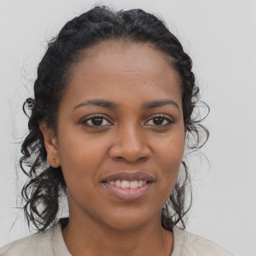 Joyful black young-adult female with long  black hair and brown eyes