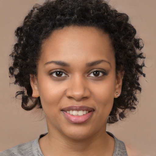 Joyful black young-adult female with medium  brown hair and brown eyes