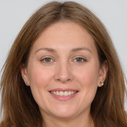 Joyful white adult female with long  brown hair and grey eyes