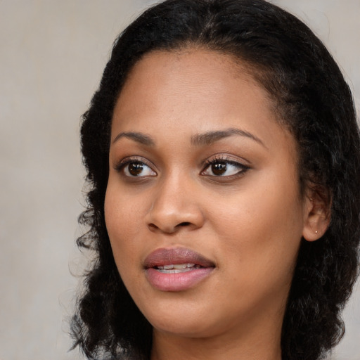 Joyful black young-adult female with long  brown hair and brown eyes