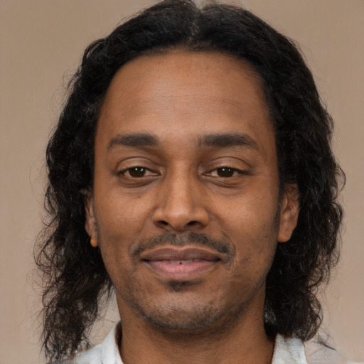 Joyful latino adult male with medium  black hair and brown eyes