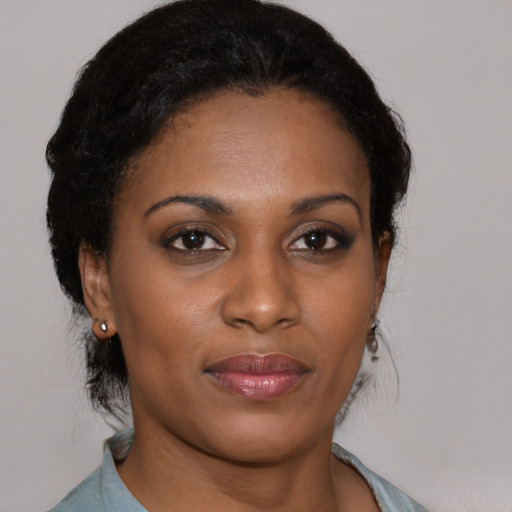 Joyful black young-adult female with medium  brown hair and brown eyes