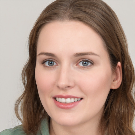 Joyful white young-adult female with long  brown hair and blue eyes