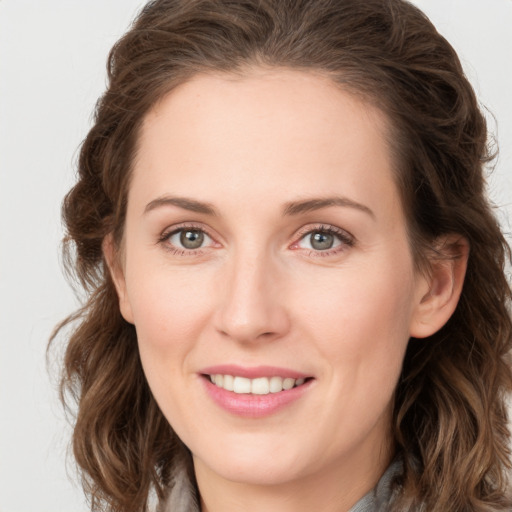 Joyful white young-adult female with long  brown hair and green eyes