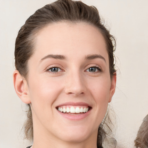 Joyful white young-adult female with medium  brown hair and grey eyes