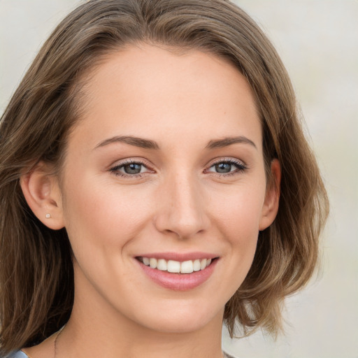 Joyful white young-adult female with medium  brown hair and green eyes