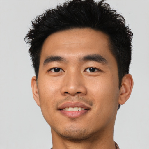 Joyful asian young-adult male with short  black hair and brown eyes