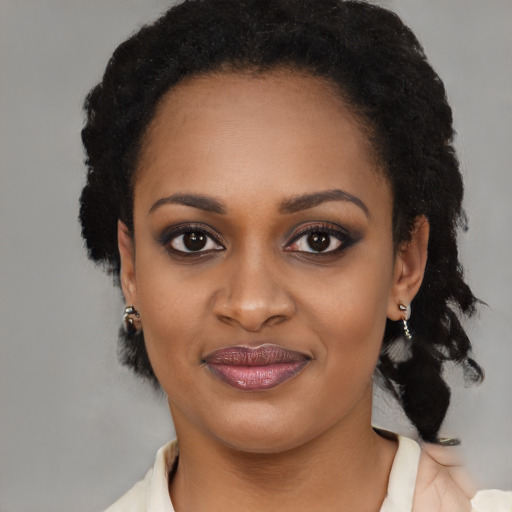 Joyful black young-adult female with long  black hair and brown eyes