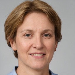 Joyful white adult female with medium  brown hair and grey eyes