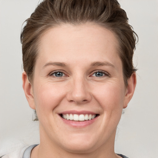 Joyful white young-adult female with short  brown hair and grey eyes