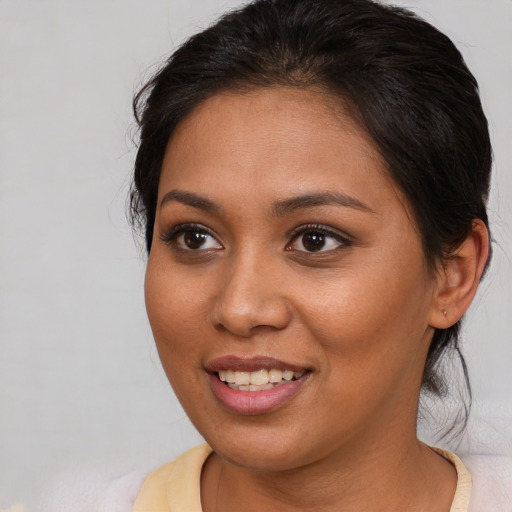 Joyful latino young-adult female with medium  brown hair and brown eyes