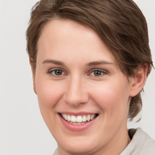 Joyful white young-adult female with short  brown hair and grey eyes