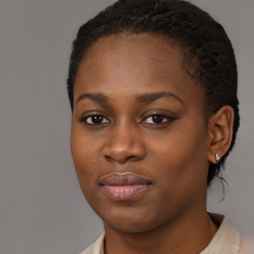 Joyful black young-adult female with short  black hair and brown eyes