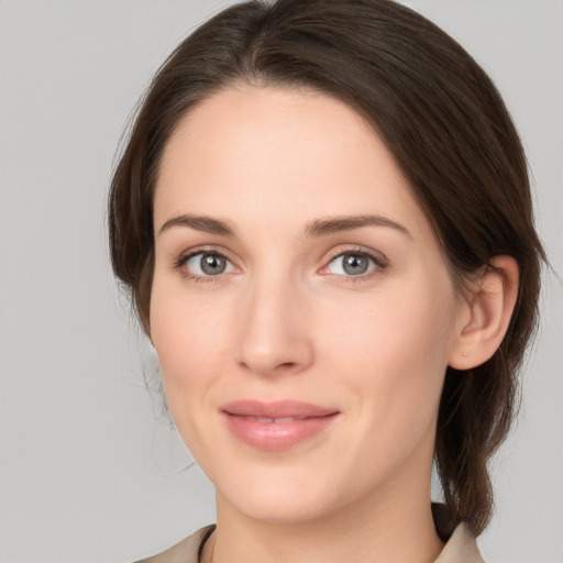 Joyful white young-adult female with medium  brown hair and grey eyes