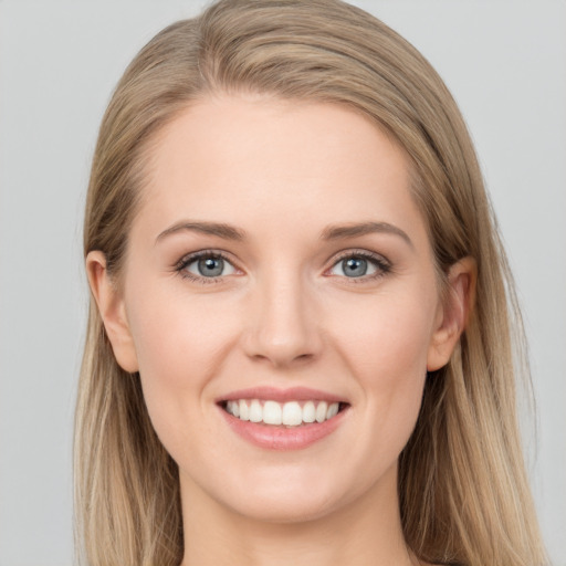 Joyful white young-adult female with long  brown hair and blue eyes