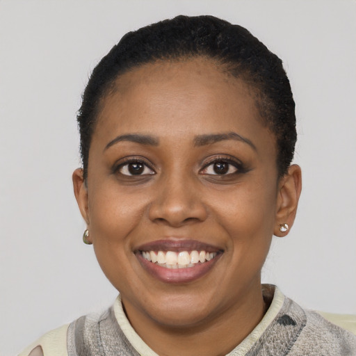 Joyful black young-adult female with short  black hair and brown eyes