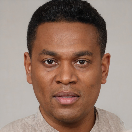 Joyful black young-adult male with short  black hair and brown eyes