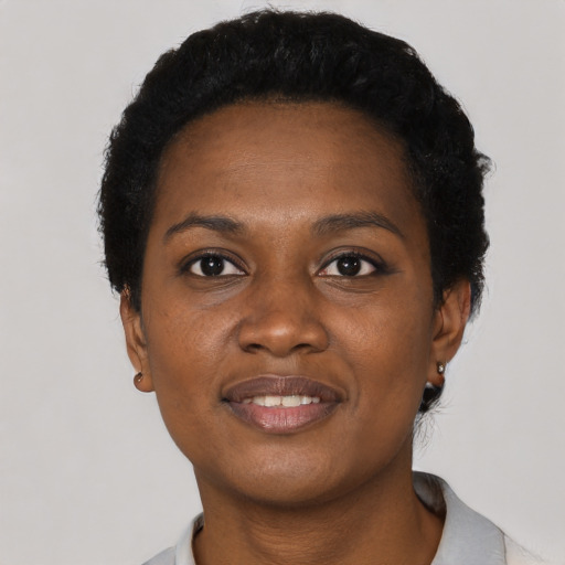 Joyful black young-adult female with short  black hair and brown eyes