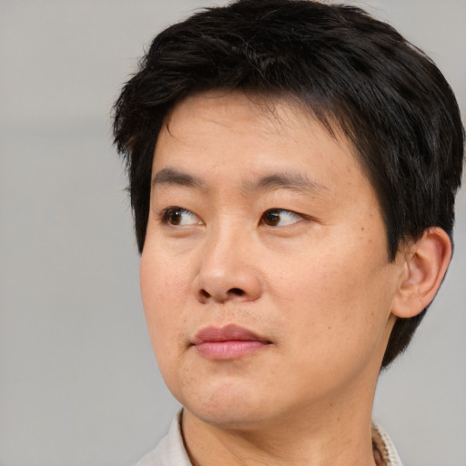 Joyful asian adult male with short  black hair and brown eyes