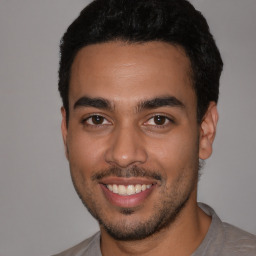 Joyful latino young-adult male with short  black hair and brown eyes