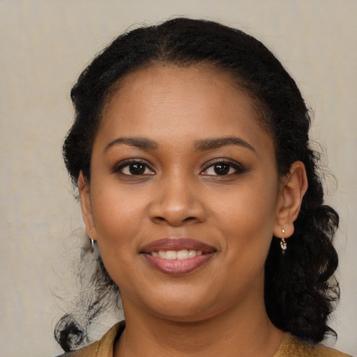 Joyful black young-adult female with long  brown hair and brown eyes