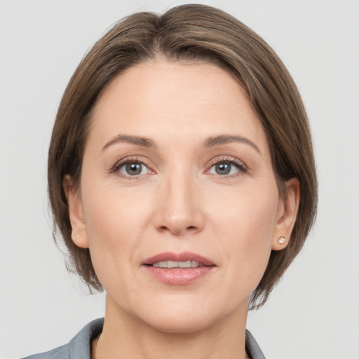 Joyful white adult female with medium  brown hair and grey eyes