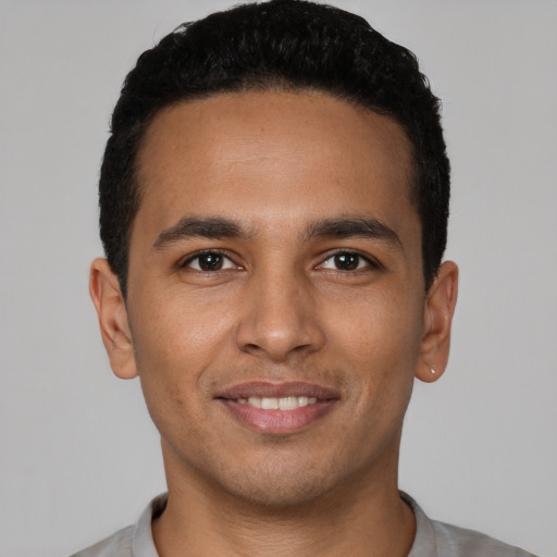 Joyful latino young-adult male with short  black hair and brown eyes