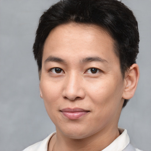 Joyful asian young-adult male with short  brown hair and brown eyes