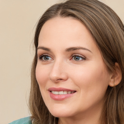 Joyful white young-adult female with long  brown hair and green eyes