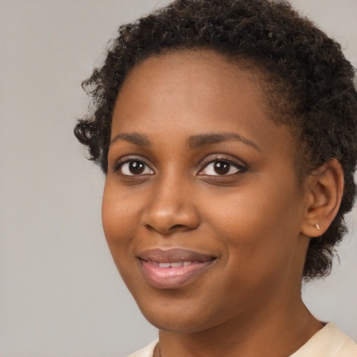 Joyful black young-adult female with short  brown hair and brown eyes