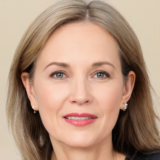 Joyful white adult female with long  brown hair and grey eyes