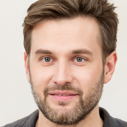 Joyful white young-adult male with short  brown hair and grey eyes