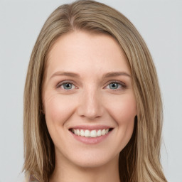 Joyful white young-adult female with long  brown hair and green eyes