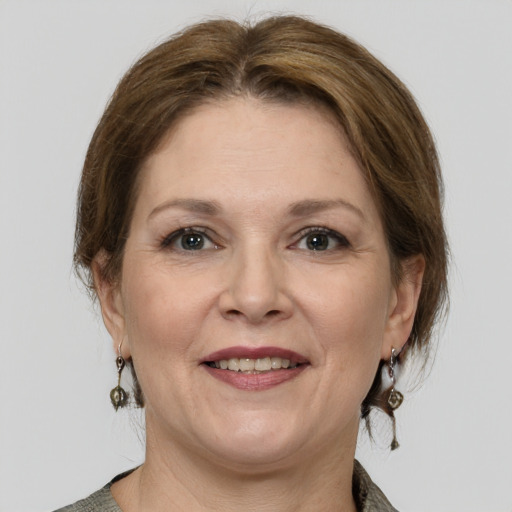 Joyful white adult female with medium  brown hair and grey eyes