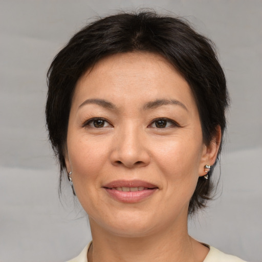 Joyful asian adult female with medium  brown hair and brown eyes