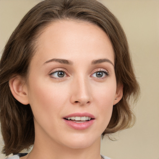 Joyful white young-adult female with medium  brown hair and green eyes