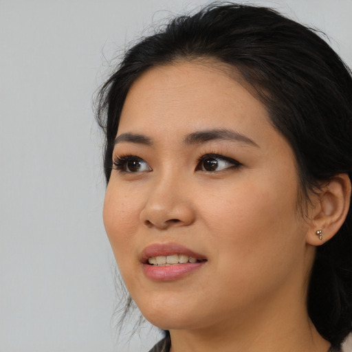 Joyful asian young-adult female with long  black hair and brown eyes
