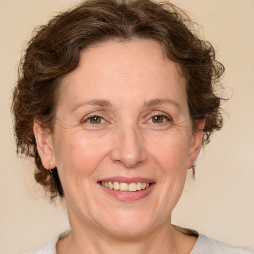 Joyful white adult female with medium  brown hair and green eyes