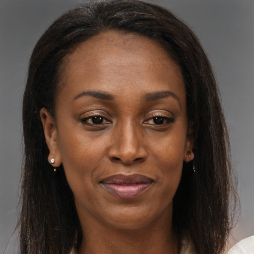 Joyful black young-adult female with long  brown hair and brown eyes