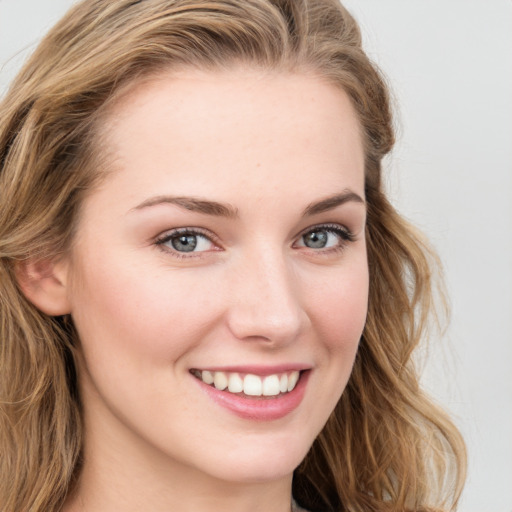 Joyful white young-adult female with long  brown hair and blue eyes